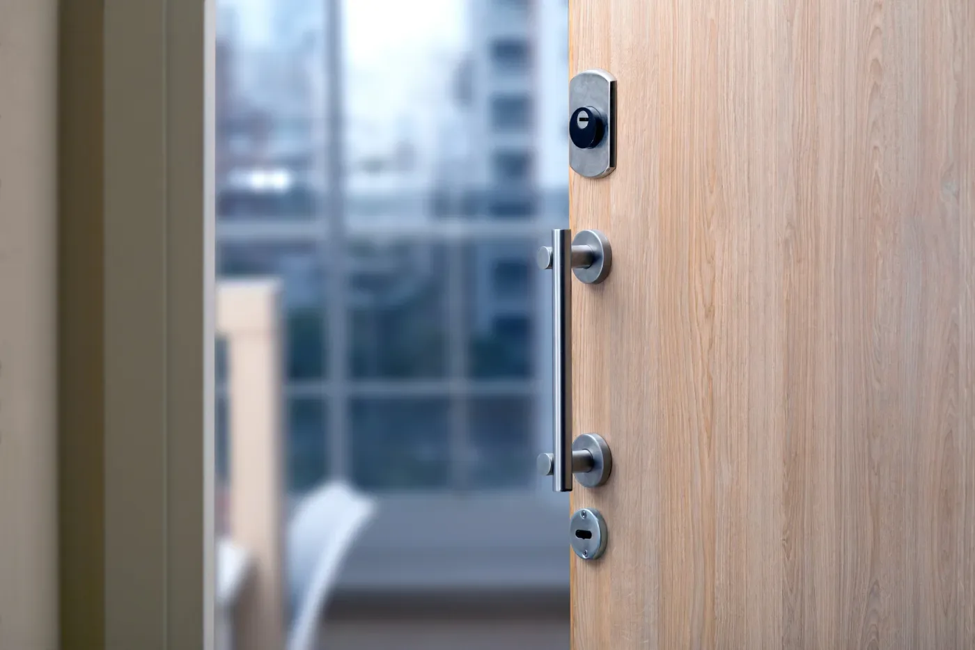 Vissage de la têtière d'une serrure multipoint sur une porte palière d'un immeuble de l'avenue Dorian (75012)